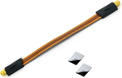 A flat cable with connectors on both ends, along with two small square adhesive pads, is presented against a white background.