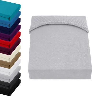 A stack of folded fitted sheets in various colors is shown on the left, and a single light gray fitted sheet is displayed on the right.