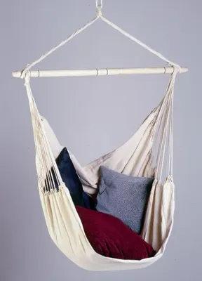 A hammock chair with pillows against a plain background.