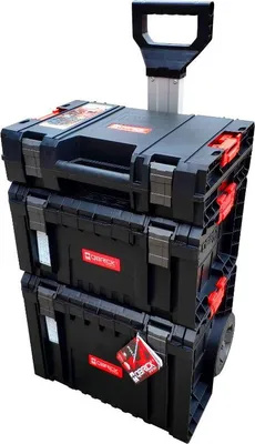 A stack of three black toolboxes with red accents, one on top of the other, with a silver retractable handle and wheels on the bottom unit.