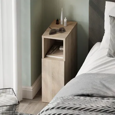 A bedside table next to a bed in a bedroom.