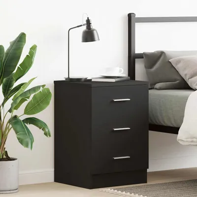A black nightstand with three drawers next to a bed.