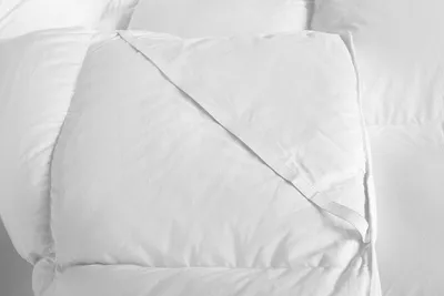 A close-up view of a white comforter or mattress topper.
