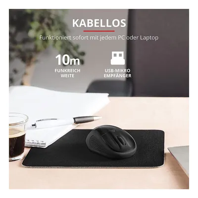 A black wireless mouse on a black mousepad on a desk, with a notebook, pen, and glass of coffee in the background. Text overlays describe features.