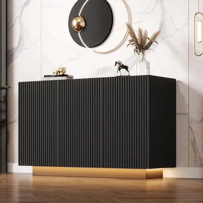 A modern black sideboard with a fluted design and LED lighting, placed against a marble-patterned wall.