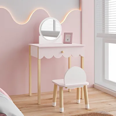 A child's vanity table and chair set in a pink room.