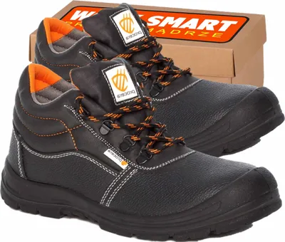 A pair of black work boots with orange accents, shown with their cardboard box in the background.