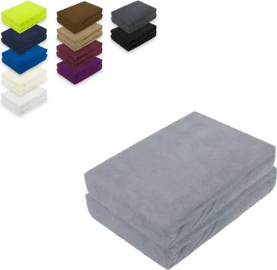 A collection of folded fabric sheets in various colors, with a larger stack of gray sheets in the foreground.