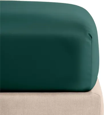 A close-up view of a dark green fitted sheet draped over a light beige mattress.