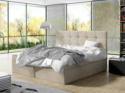 A bedroom with a large bed and a view of trees outside.