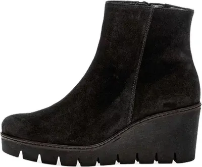 A studio shot of a black suede wedge boot.
