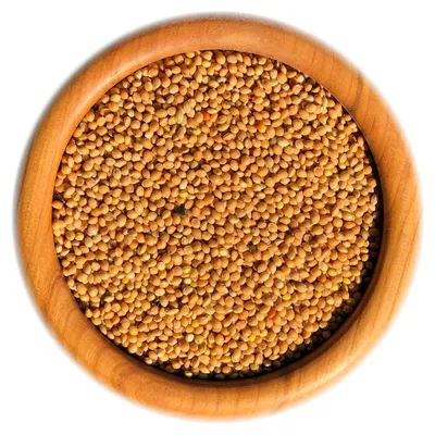 A wooden bowl filled with yellow millet seeds.