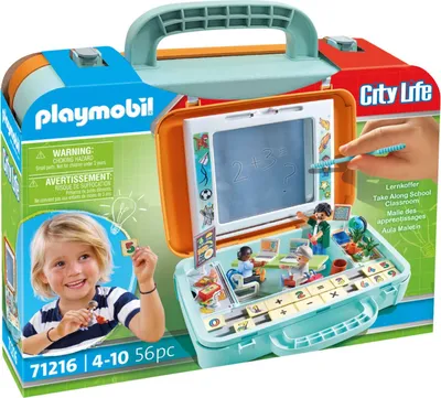 The image shows the packaging of a Playmobil Take Along School Classroom playset. The packaging is open, revealing the playset inside, which includes miniature figures, furniture, and a chalkboard.