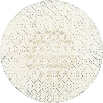 A white round metal bistro table with a decorative heart pattern.
