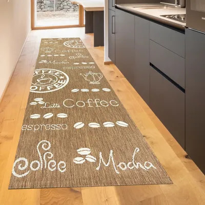 A long runner rug with coffee-themed designs is laid out in a hallway, extending towards a kitchen area.