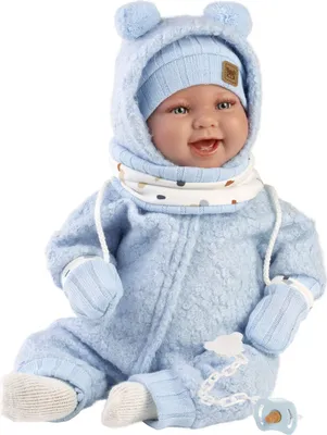 A baby doll dressed in a blue outfit with a hat and mittens, sitting down.