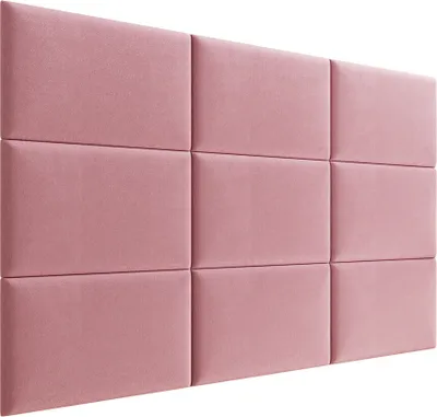 A wall panel made of upholstered squares in a pink color.
