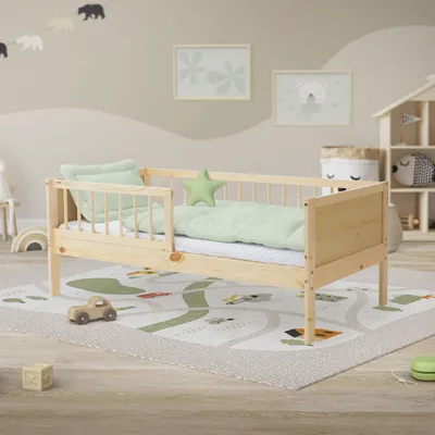 A child's bedroom with a wooden toddler bed, rug, and wall decorations.