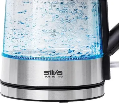 Close-up of the bottom part of a glass electric kettle with water boiling inside.
