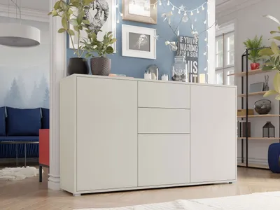 A modern living room with a white sideboard, blue sofa, and decorative elements.