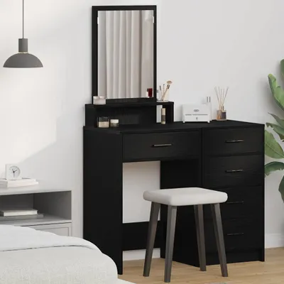 A black vanity table with a mirror and stool in a bedroom setting.