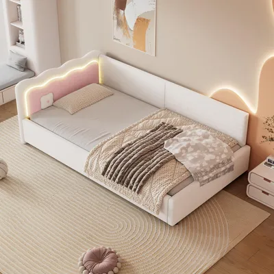 A bedroom scene featuring a white daybed with LED lighting and decorative pillows and blankets.