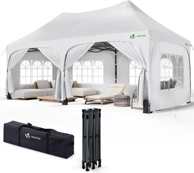 A white pop-up gazebo set up with outdoor furniture inside, with its carrying bag and folded frame shown below.