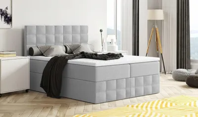 A bedroom scene with a bed, nightstand, and lamp.
