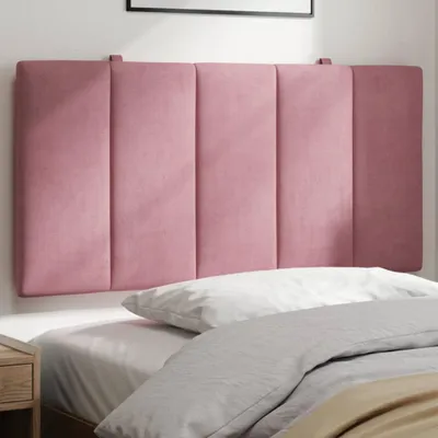 A pink upholstered headboard is mounted on a wall above a bed with white and gray bedding.
