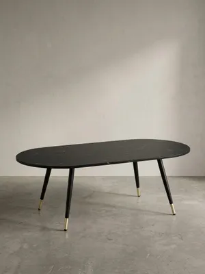 Ovaler Couchtisch 120x60x41,5 cm mit schwarzer Marmor-Dekor-Platte und konischen Metallbeinen freigestellt vor neutralem weißem Hintergrund._#sku_SAFWL6.872#