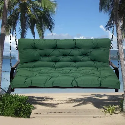 A green swing cushion is shown in a tropical beach setting with palm trees and the ocean in the background.