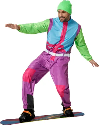 A man wearing a retro ski suit and beanie, posing on a snowboard.