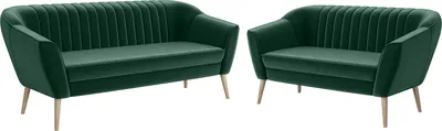Two green velvet sofas are shown against a white background.