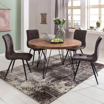 A round dining table with four chairs in a dining room setting.