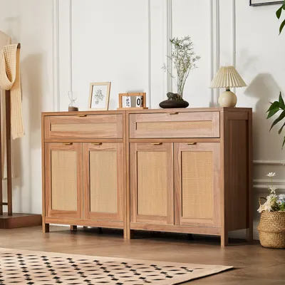 A wooden cabinet with rattan doors and drawers, decorated with a lamp, a plant, and a calendar.
