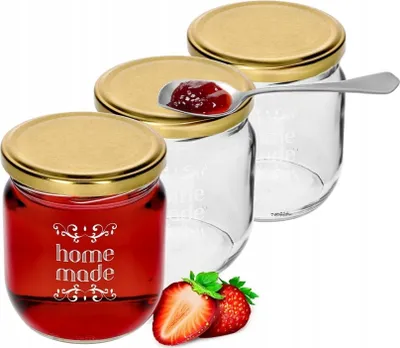 Three glass jars with gold lids, one filled with red jam and labeled 'home made', and two empty jars. A spoon with jam is resting on one lid, and strawberries are in the foreground.