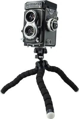 A vintage Rolleiflex camera is mounted on a flexible tripod.