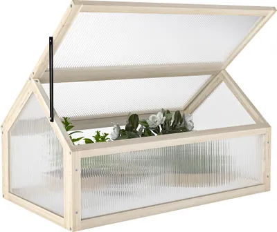 A wooden greenhouse with a clear, ribbed plastic cover, containing plants.