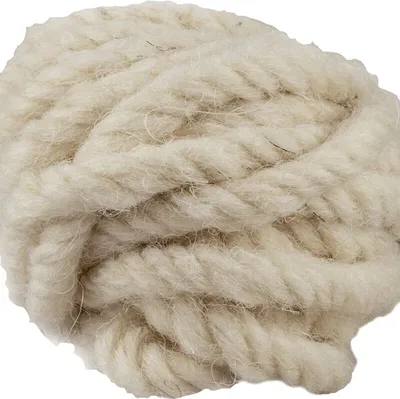 A close-up view of a ball of thick, cream-colored wool twine.