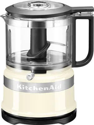 A cream-colored KitchenAid mini food processor is shown against a white background.