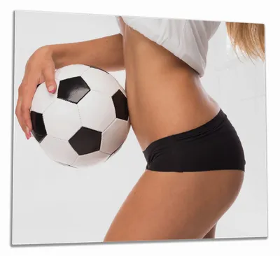 Produktbild von Wallario Herdabdeckplatte aus Glas, Größe 60 x 52 cm 1-teilig, Motiv Fußball - sexy Frau mit einem Fußball