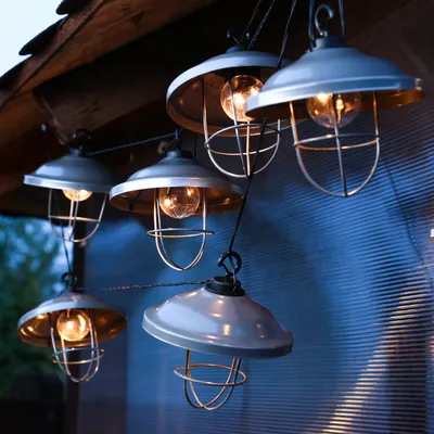 A string of outdoor lights hanging from a wooden overhang.