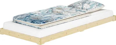 A low-profile bed with bedding and a pillow, shown against a white background.