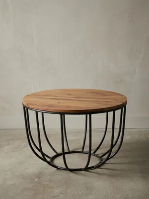 Runder Sofatisch im angesagten Industrial Design freigestellt. Der Materialmix aus warmem Massivholz in Braun und dem korbartigen schwarzen Metallgestell wirkt leicht und modern._#sku_SAFWL5.677#