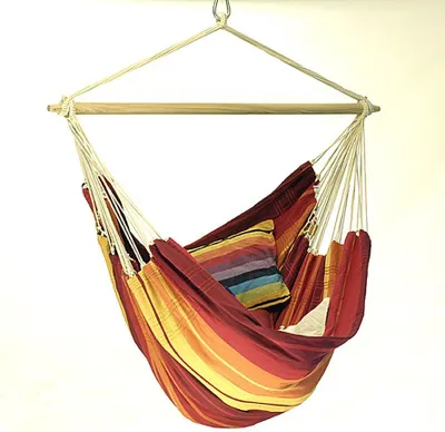A colorful striped hammock chair hanging from a wooden spreader bar.