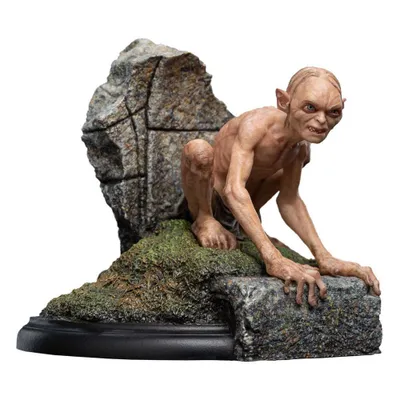 A Gollum figurine from The Lord of the Rings, perched on a rocky, mossy base.
