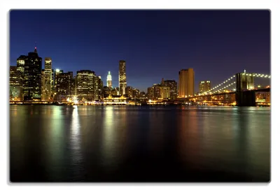 Produktbild von Wallario Frühstücksbrettchen aus Glas 20 x 30 cm mit rutschfesten Füßen, Motiv New York Skyline - Brooklyn Bridge und Manhattan am Abend