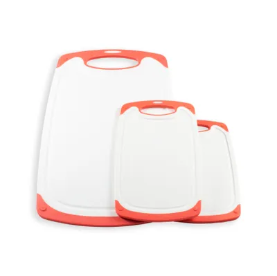 A set of three white cutting boards with orange trim and handles, arranged in a staggered formation against a white background.