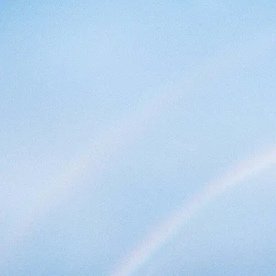 A light blue sky with a faint rainbow visible.