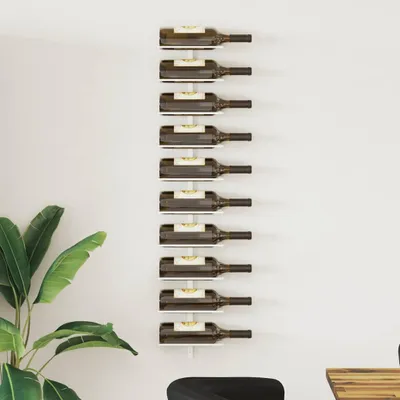 A white wall with a vertical wine rack holding ten bottles of wine.